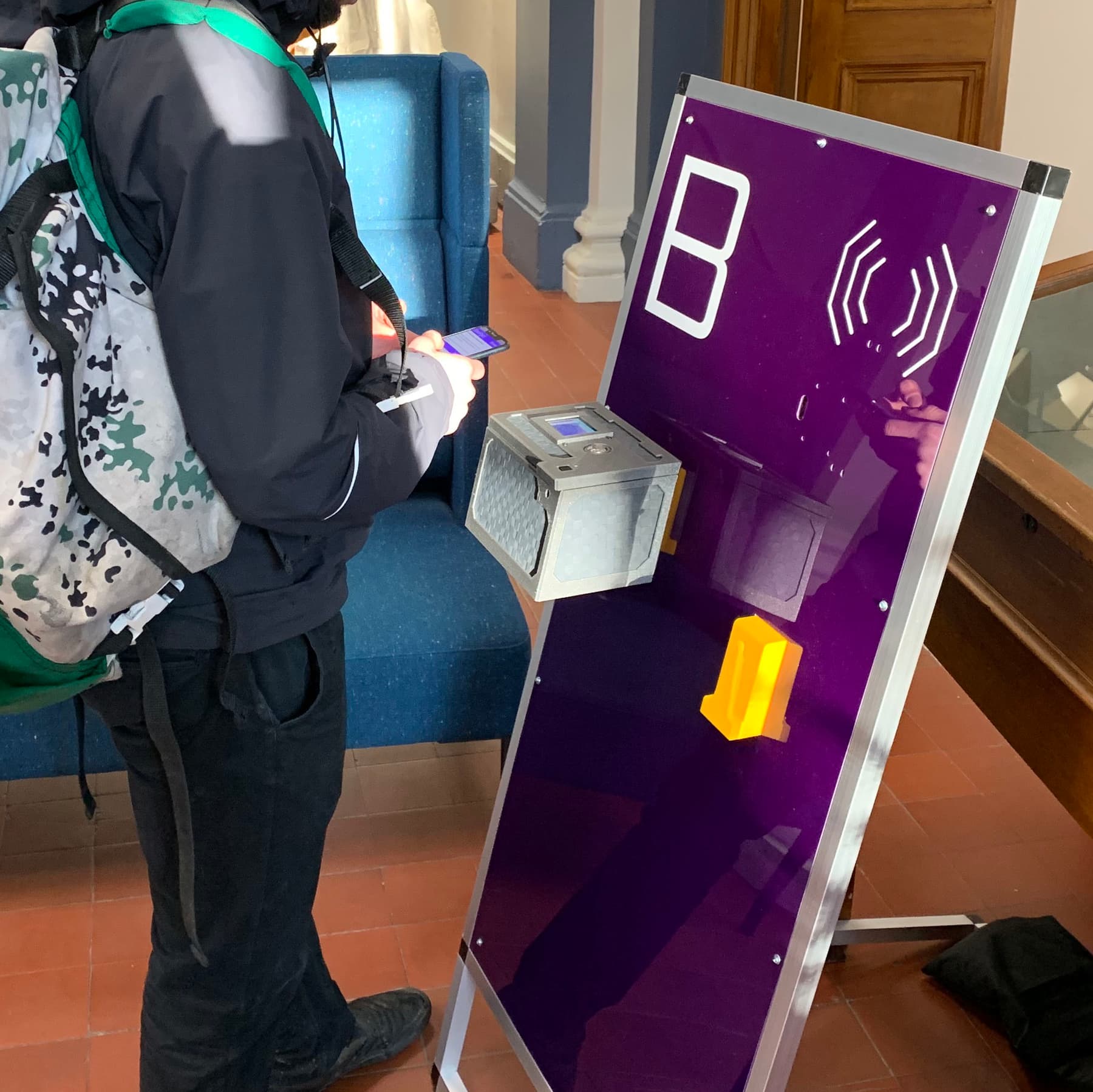 A bicycle courier interacts with a GeoPact hub and lockbox using their phone.