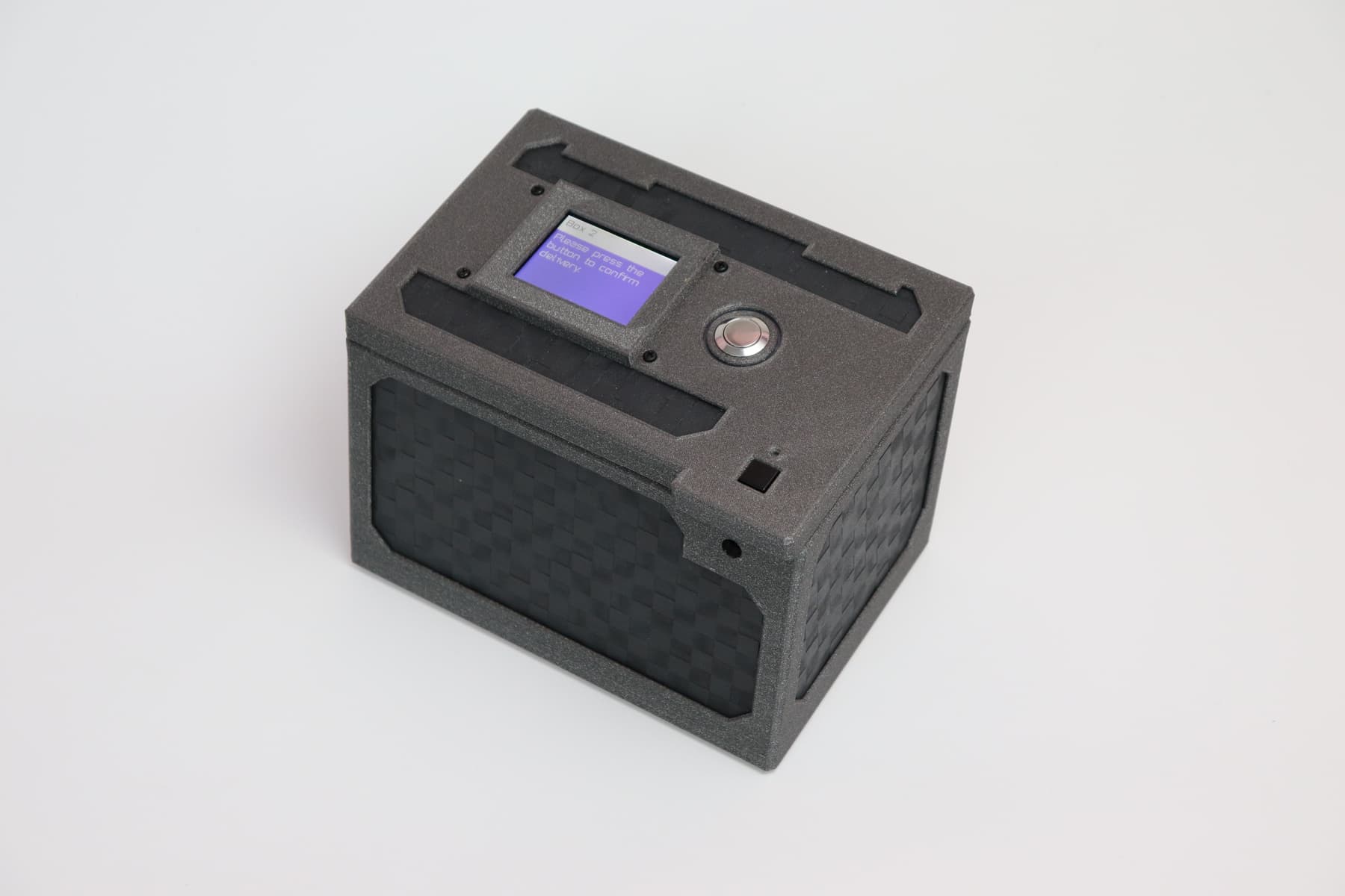 A GeoPact lockbox displaying the message 'please press the button to confirm
delivery'.