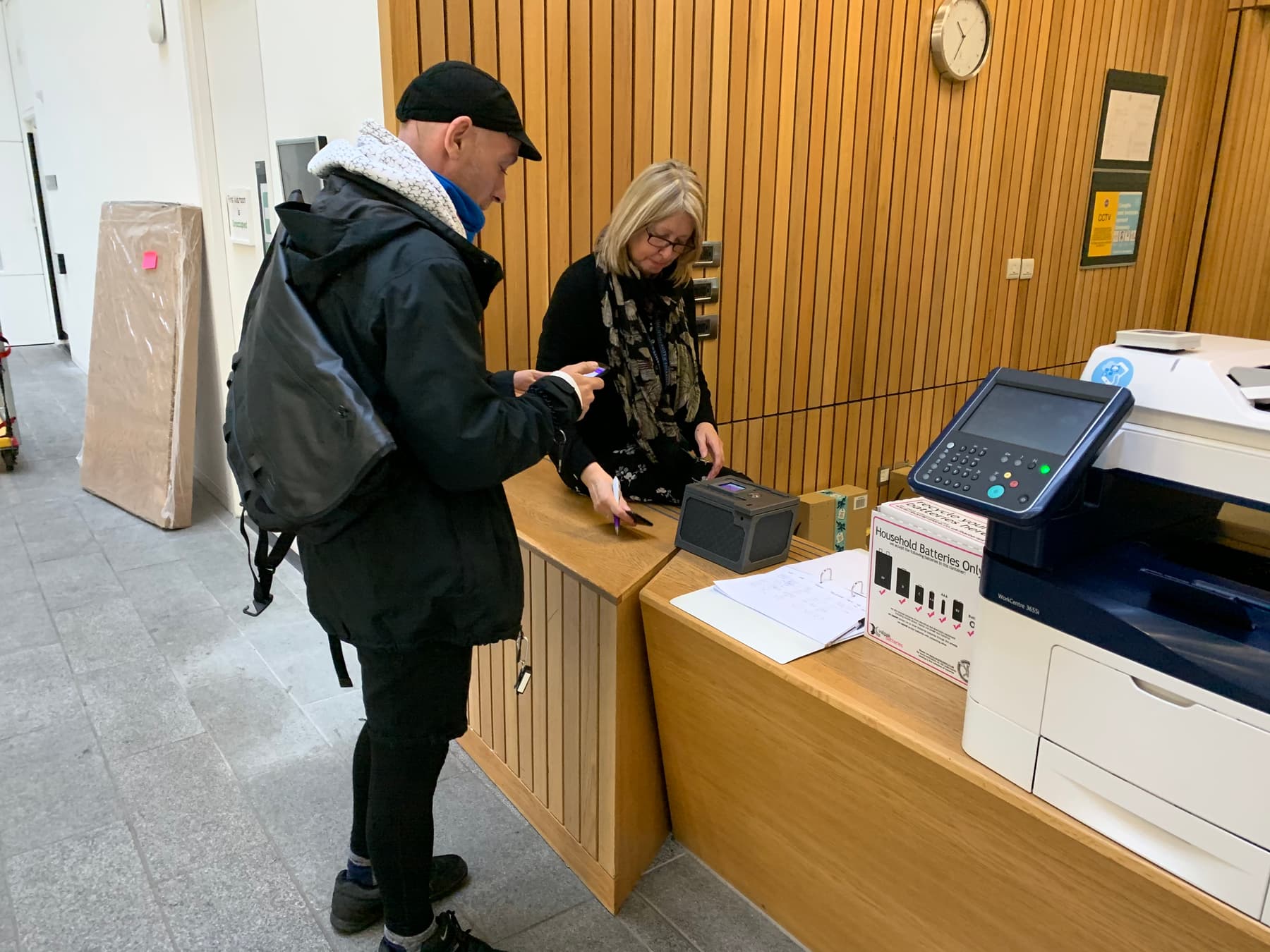 A bicycle courier delivers a lockbox to a receptionist during the GeoPact
study.