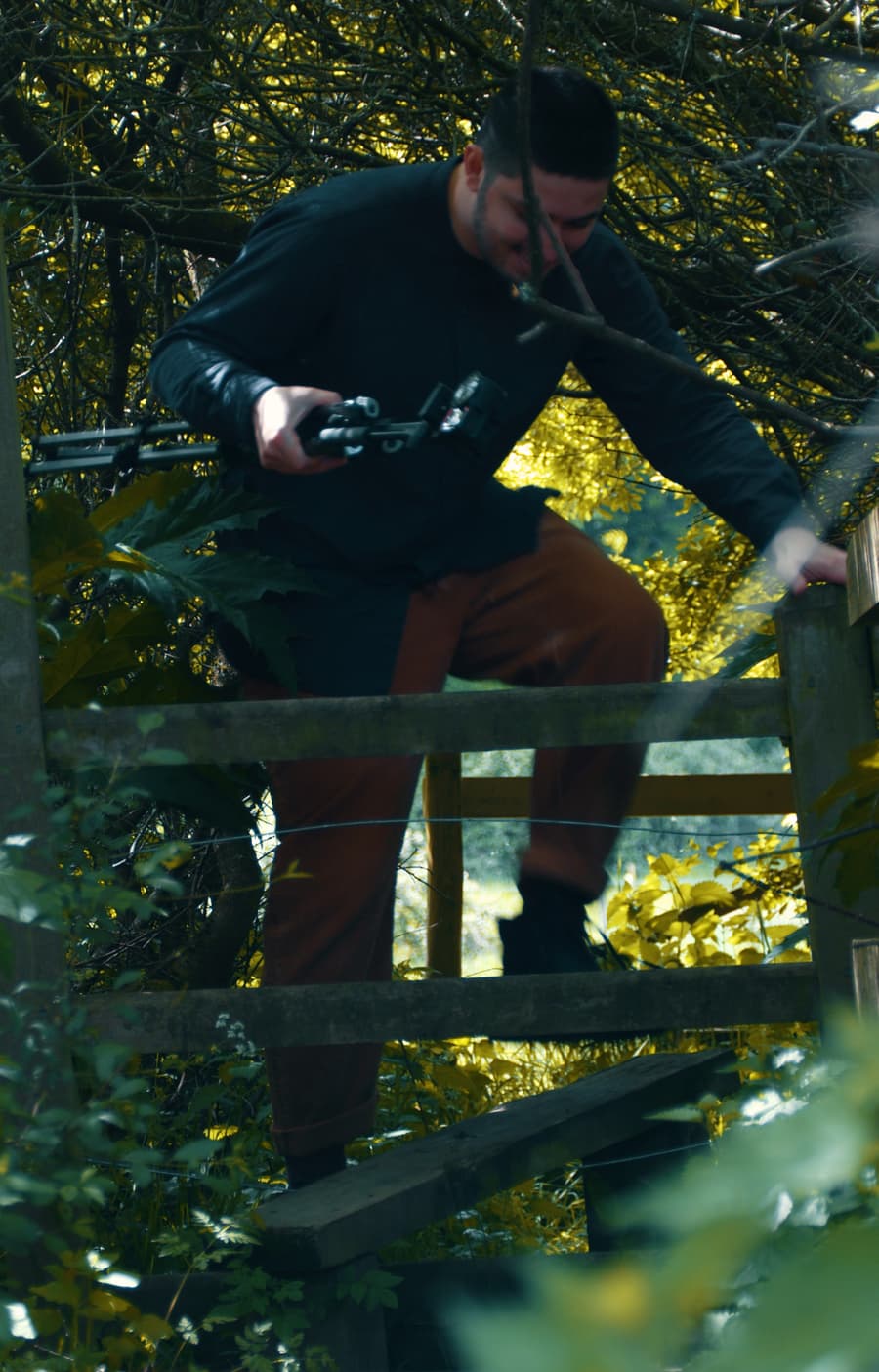 Joe climbs over a stile.