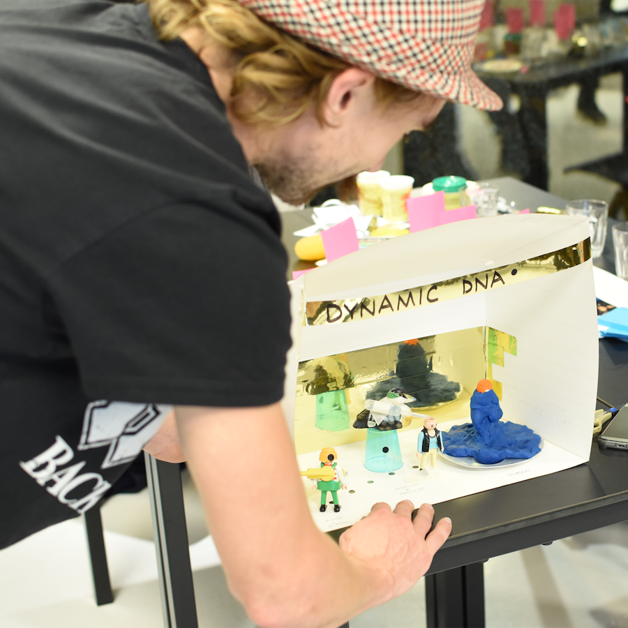 A workshop participant presents their diorama, entitled 'Dynamic DNA'.